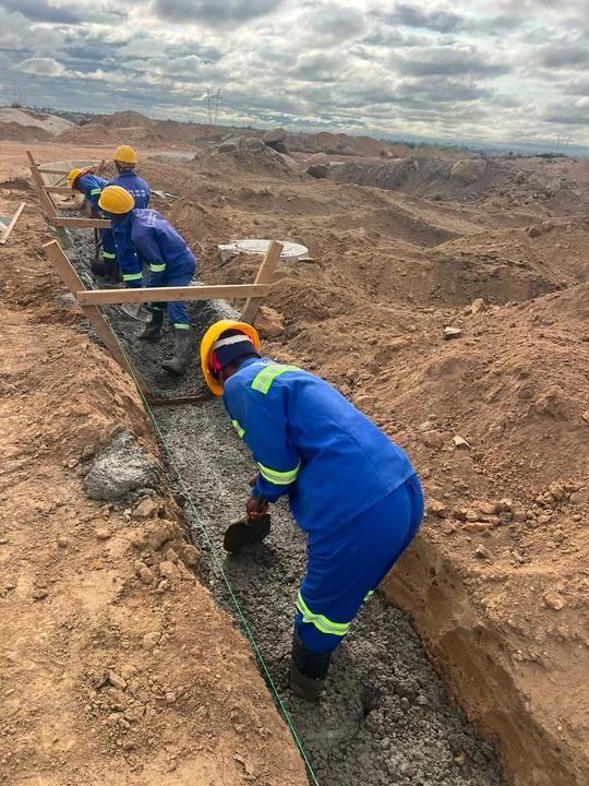 Crew placing concrete drain lining
