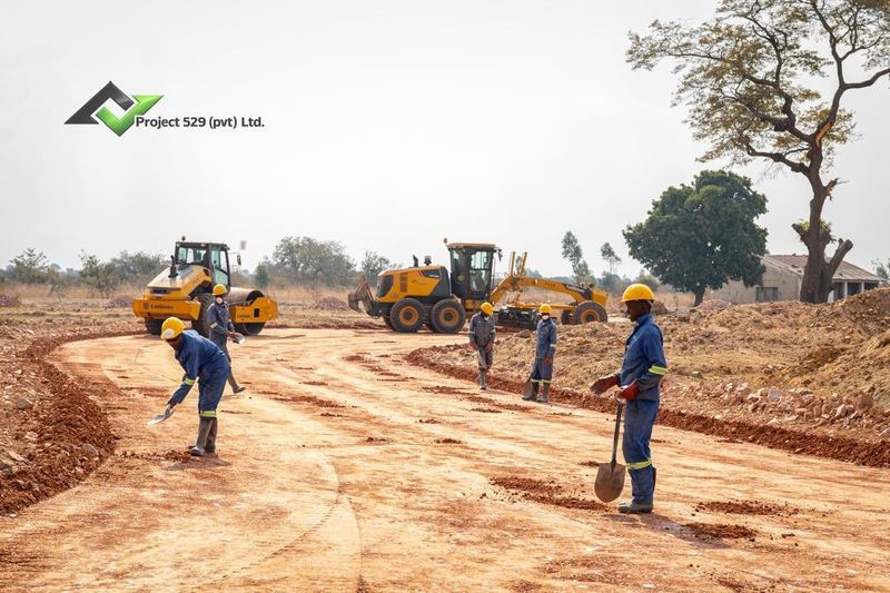 Road crew working alongside a roller and grader